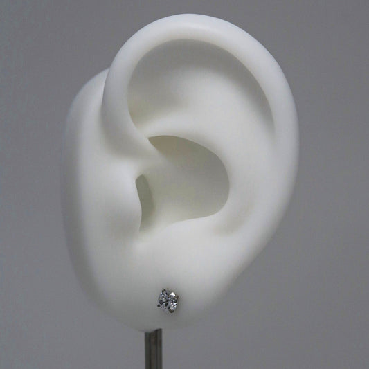 White ear model with a diamond stud earring on a gray background