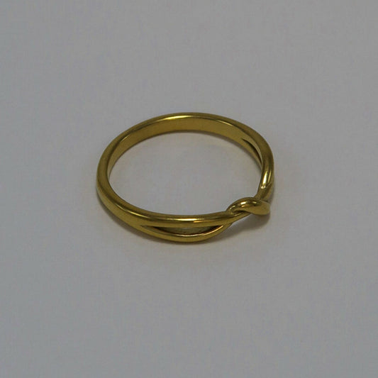 Gold ring with a twisted design on a light gray background