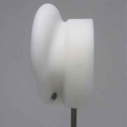 The back of a white ear model with a silver flat back earring post on a gray background